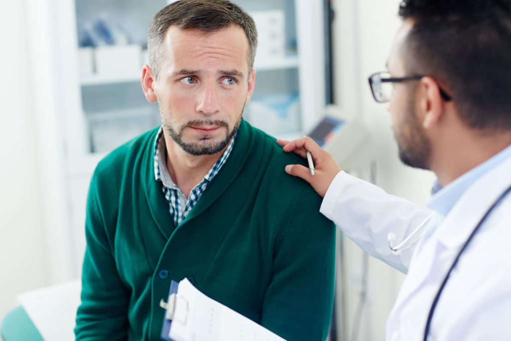 Homem conversando com o médico