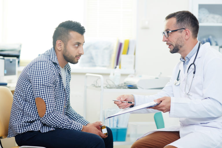 Homem conversando com médico